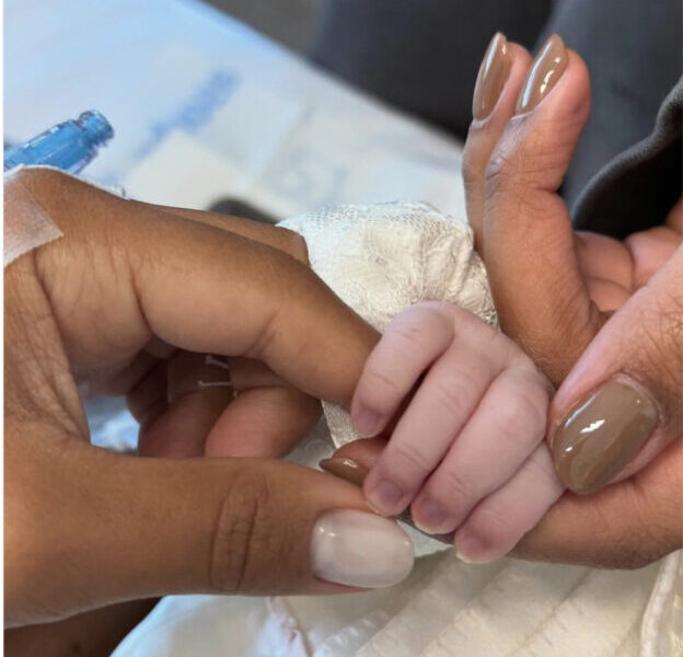 Ludmilla e Brunna segurando a filha Zuri após o parto